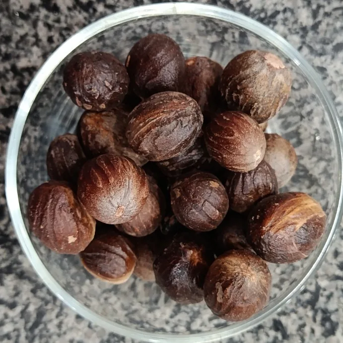 Whole nutmeg (Jaifal) in a glass bowl at Awaisia Pansar — جائفل