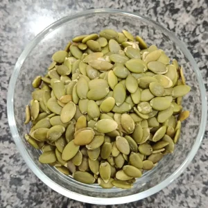 Shelled pumpkin seeds in a glass bowl at Awaisia Pansar — کدو کے بیج