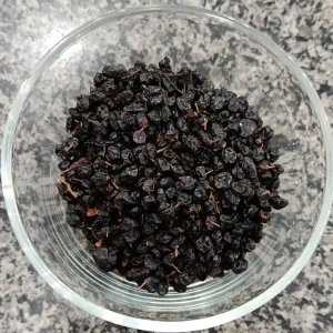 Whole dried barberries (Zarishk Shireen) in a glass bowl at Awaisia Pansar — زرشک شیریں